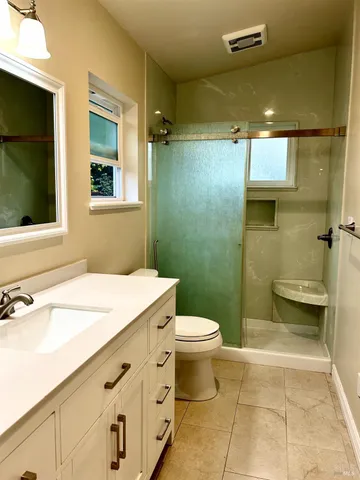 a bathroom with a sink a toilet and shower