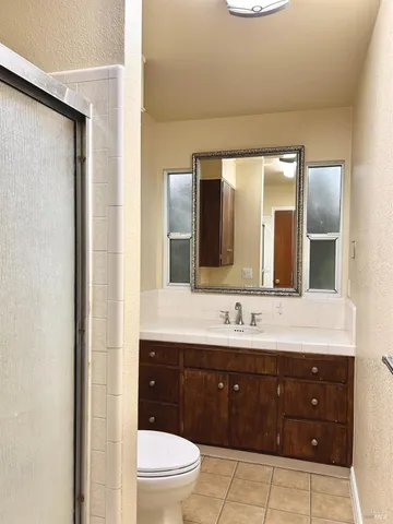 a spacious bathroom with a granite countertop sink mirror and toilet
