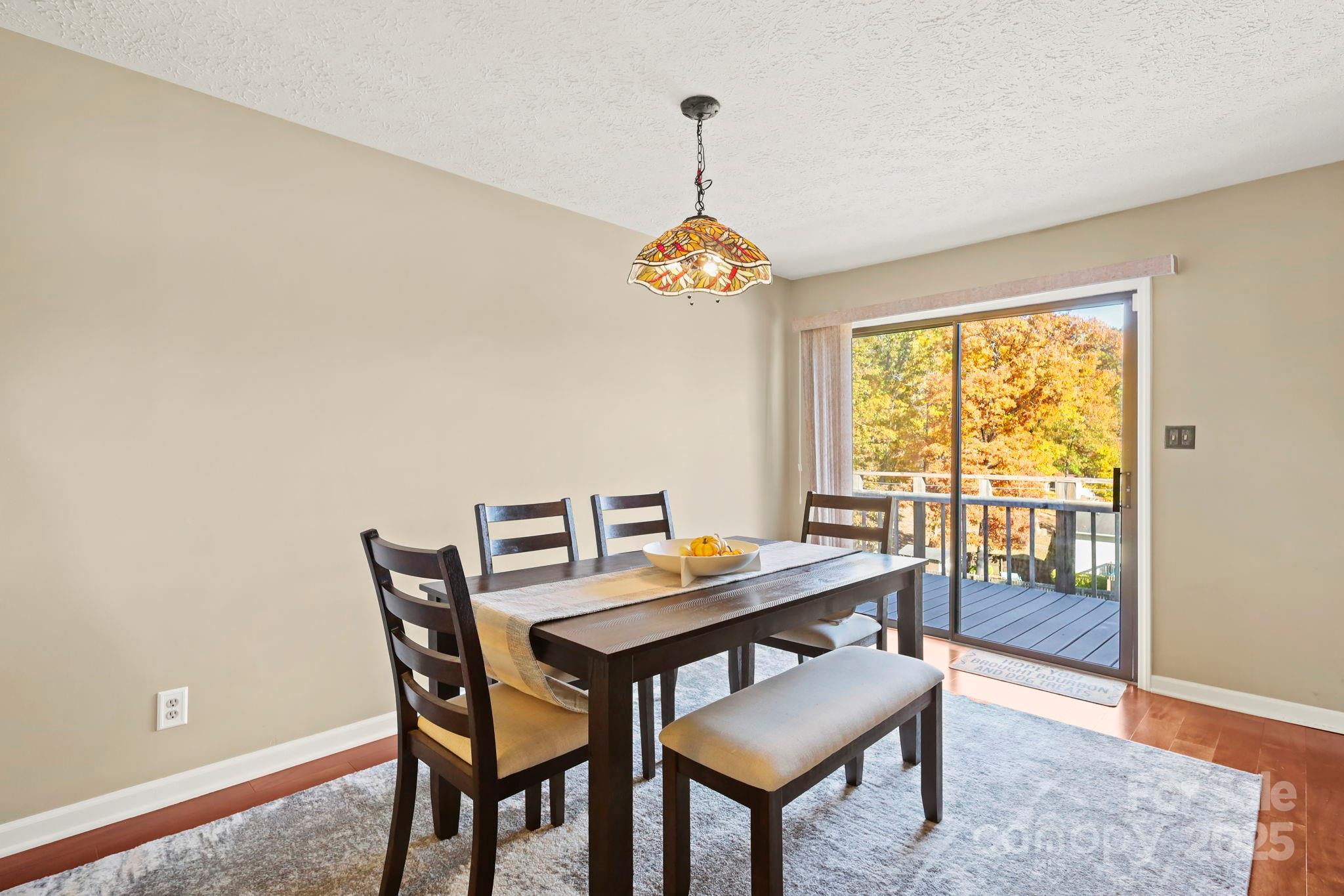 2216 Olde Well Road Hudson, NC 28638 - Photo 13 of 48 a dining room with wooden floor a chandelier a wooden table and chairs