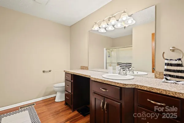 a bathroom with a granite countertop sink a toilet and a mirror