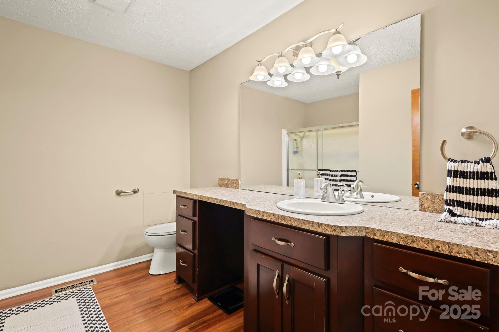 2216 Olde Well Road Hudson, NC 28638 - Photo 16 of 48 a bathroom with a granite countertop sink a toilet and a mirror
