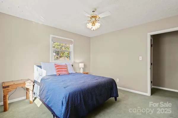 a spacious bedroom with a bed and a chandelier