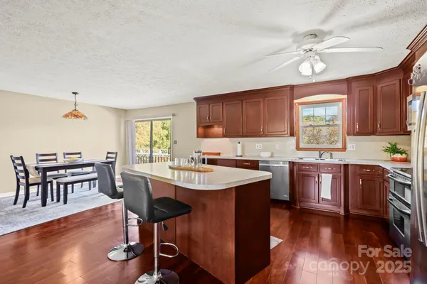 a open kitchen with cabinets a dining table and chairs with wooden floor