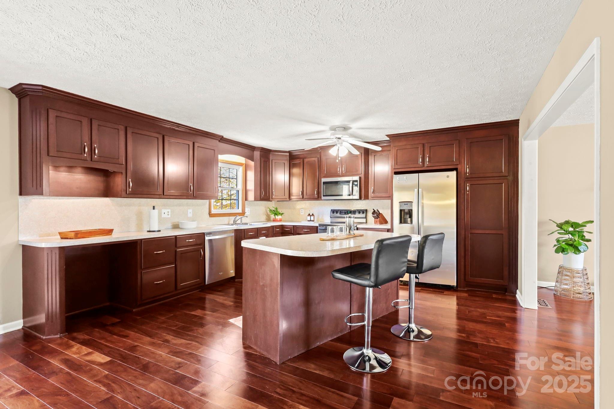 2216 Olde Well Road Hudson, NC 28638 - Photo 10 of 48 a kitchen with stainless steel appliances granite countertop a refrigerator a sink dishwasher a stove with wooden cabinets and floor