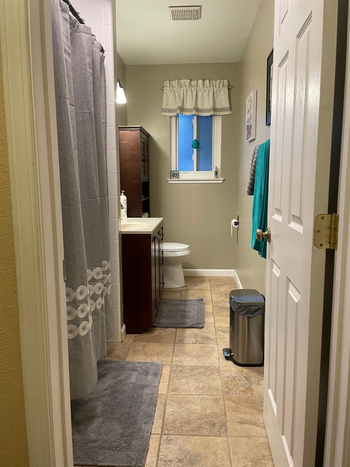 1606 Bay Meadows Drive Modesto, CA 95350 - Photo 14 of 20 a bathroom with a sink a toilet and mirror