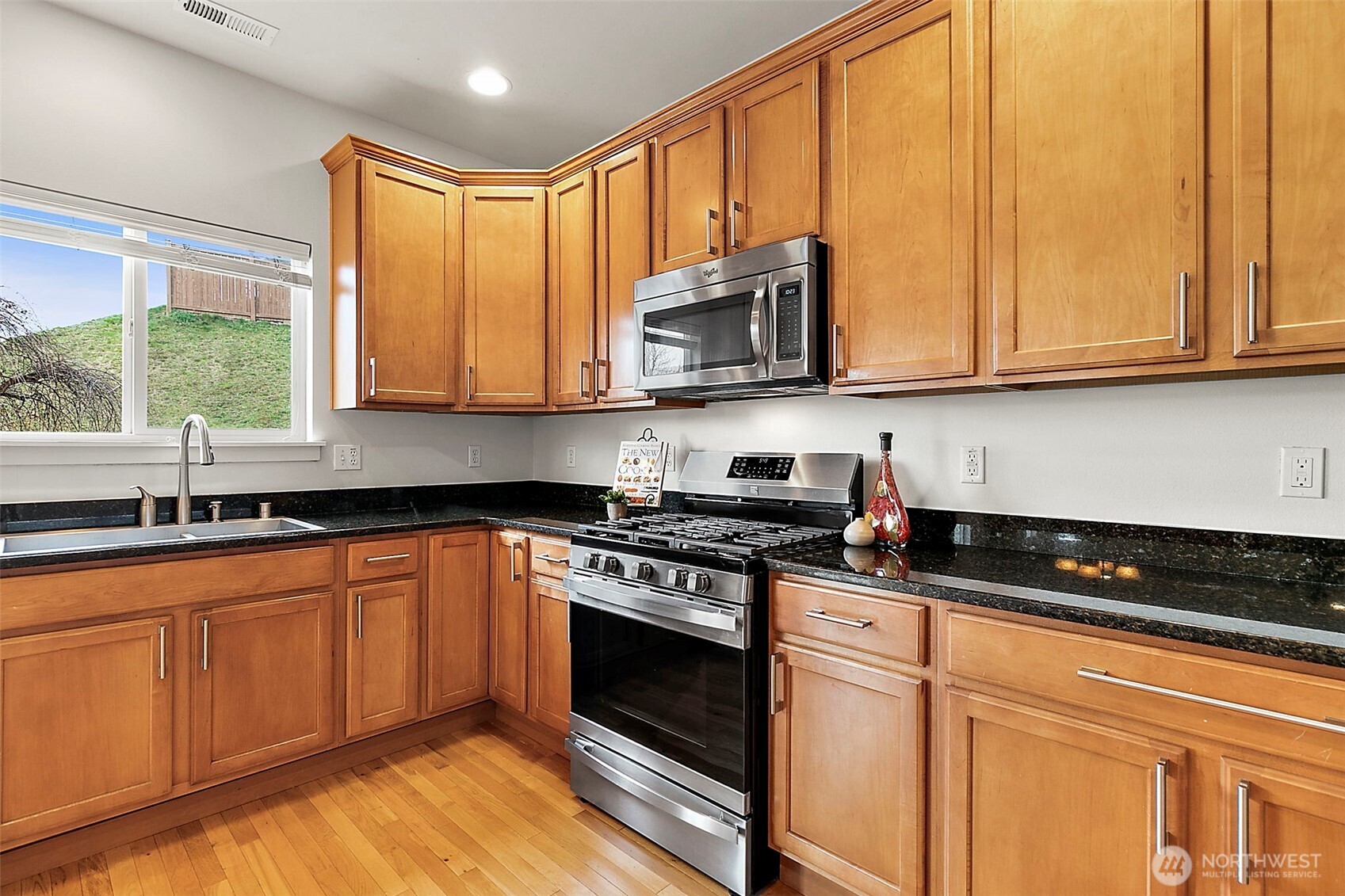 27729 257th Avenue Southeast Maple Valley, WA 98038 - Photo 12 of 40 a kitchen with stainless steel appliances granite countertop a stove a sink and a microwave