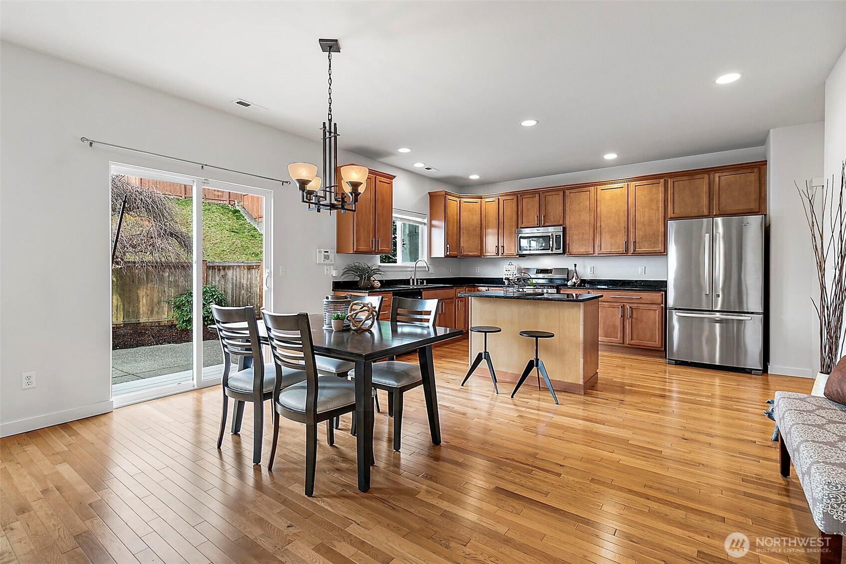 27729 257th Avenue Southeast Maple Valley, WA 98038 - Photo 8 of 40 a kitchen with stainless steel appliances granite countertop wooden floor dining table and chairs