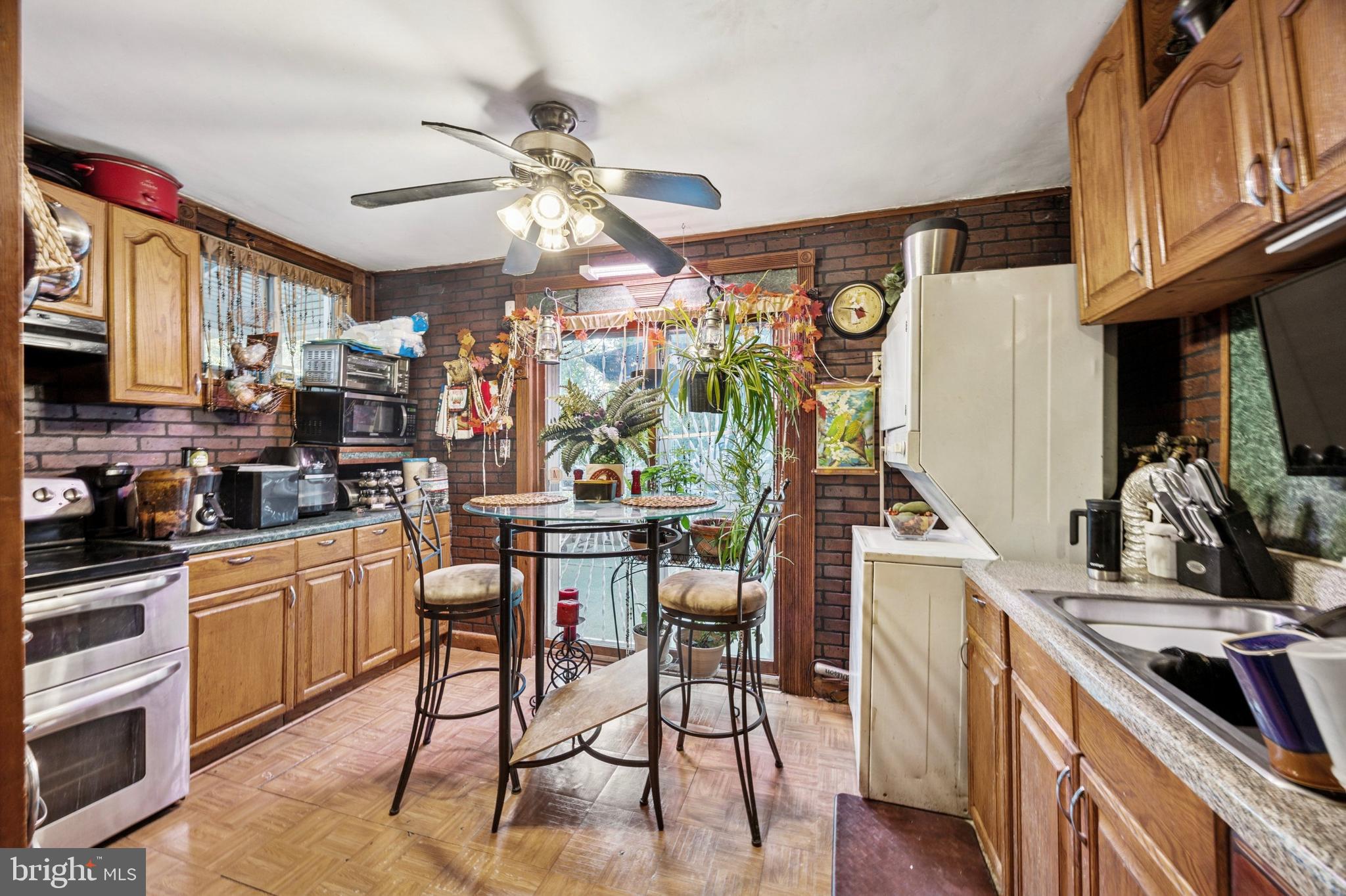 722 Yeadon Avenue Lansdowne, PA 19050 - Photo 11 of 23 a kitchen with stainless steel appliances granite countertop a stove top oven a sink a dining table and chairs with wooden floor