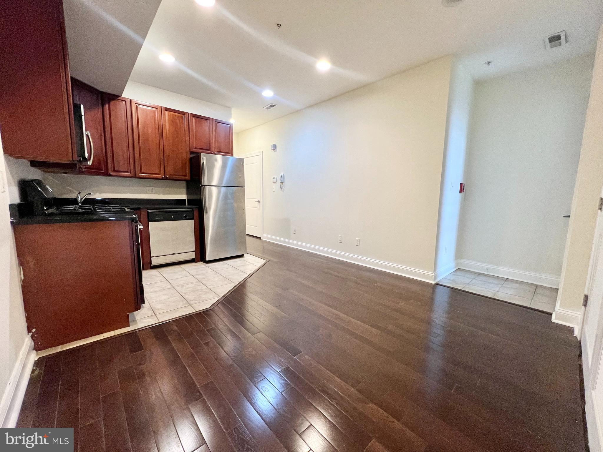 1806 North 16th Street, Unit A Philadelphia, PA 19121 - Photo 3 of 8 a kitchen with stainless steel appliances granite countertop a refrigerator and a stove top oven