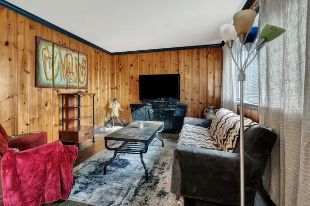 a living room with furniture a flat screen tv and a large window
