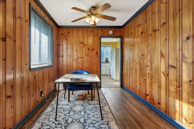 a dining room with chandelier and wooden floor