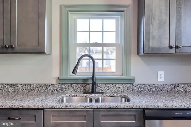 a kitchen with granite countertop a sink and cabinets