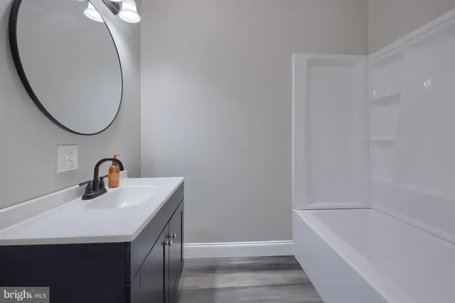 a bathroom with a sink a bathtub and a mirror