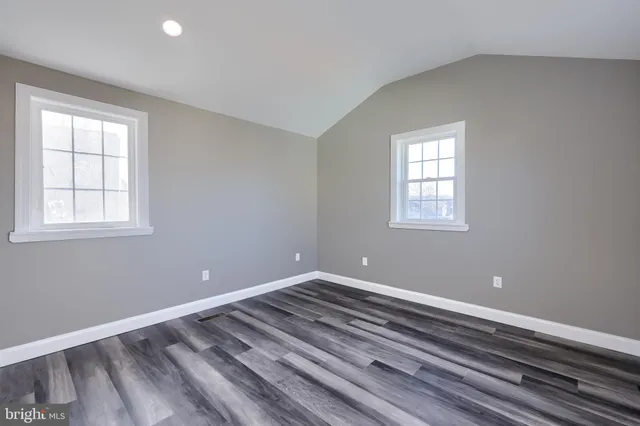 a view of a room with wooden floor and windows