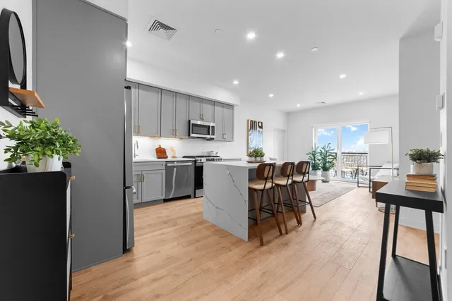 a kitchen with a table chairs refrigerator and microwave