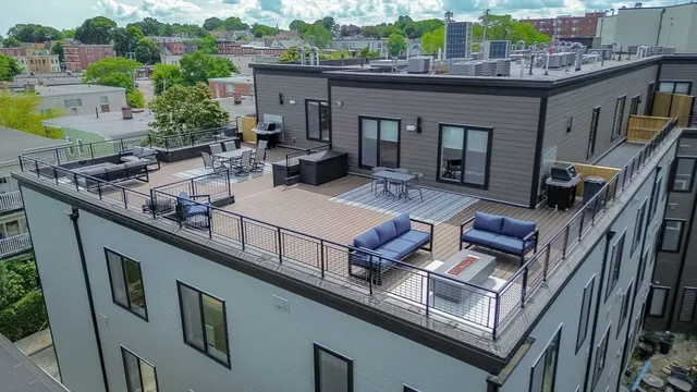 a view of a patio with couches table and chairs with wooden floor and fence