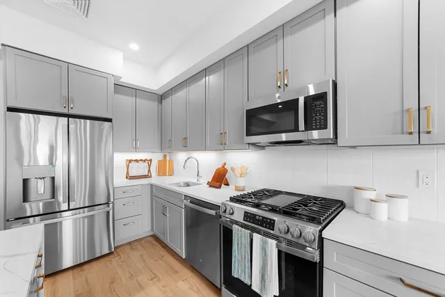 a kitchen with stainless steel appliances a stove microwave and a refrigerator