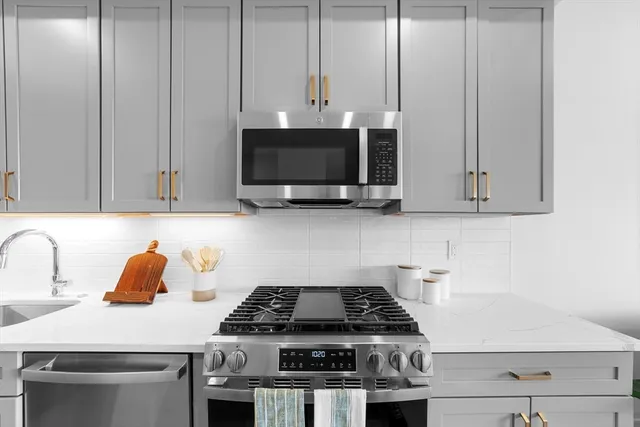 a kitchen with stainless steel appliances granite countertop a stove a microwave and a sink