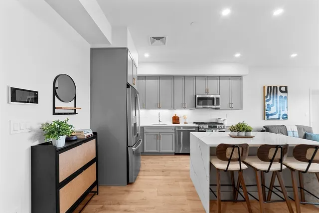 a kitchen with white cabinets and stainless steel appliances