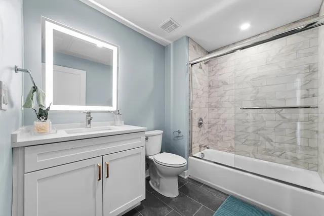 a bathroom with a sink toilet vanity and shower