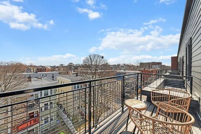 a view of a balcony with wooden floor next to a city view