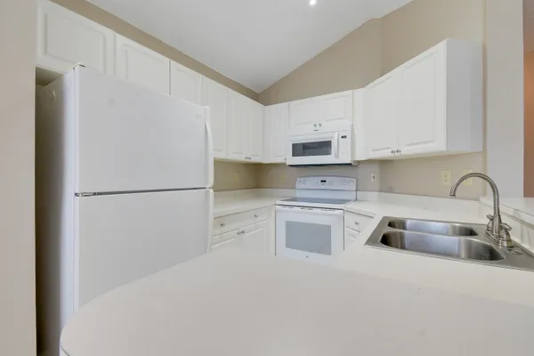a kitchen with stainless steel appliances granite countertop white refrigerator stove a sink and dishwasher