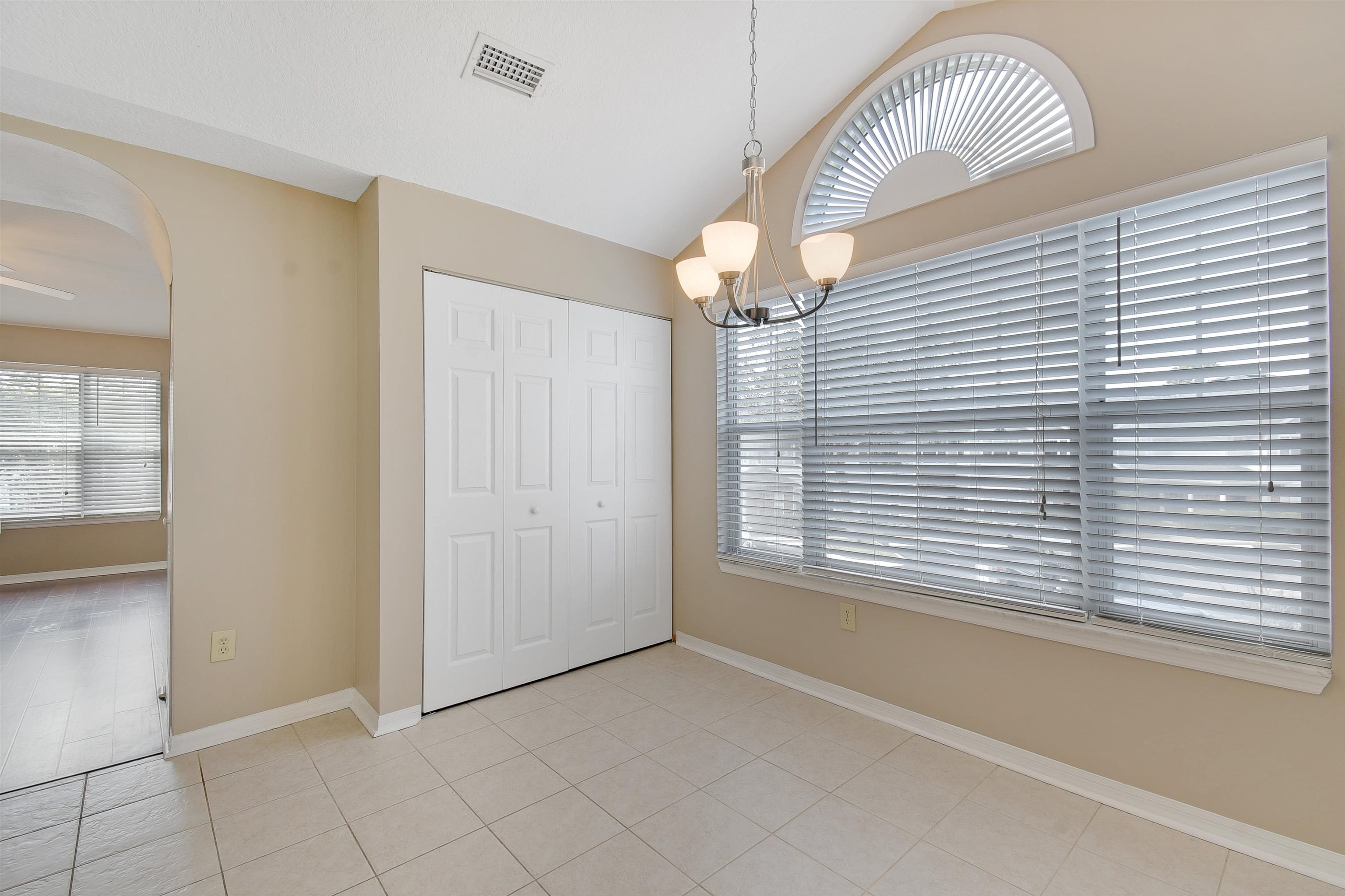 24200 Harbour Vista Circle St. Augustine, FL 32080 - Photo 17 of 30 an empty room with wooden floor chandelier fan and windows