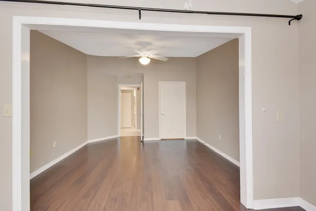 a view of an empty room with wooden floor