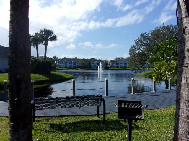 a view of a bench in the garden near a lake