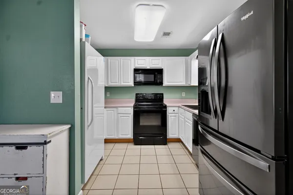 a kitchen with a refrigerator a stove and a sink