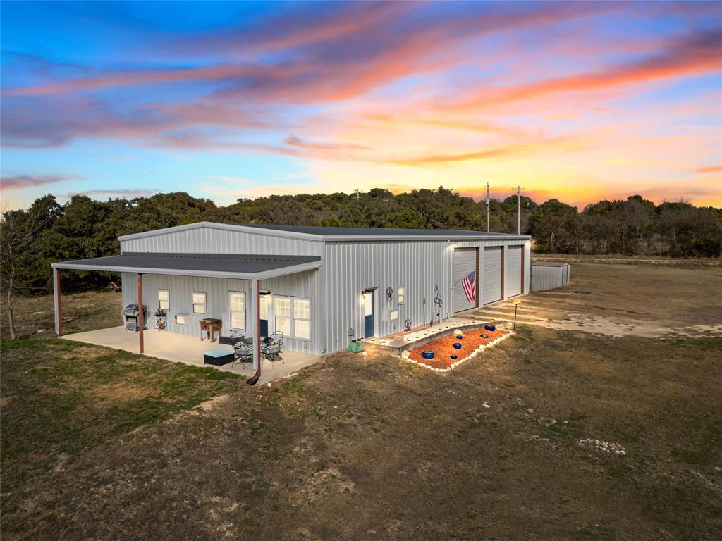 a view of a white house with a big yard and large trees