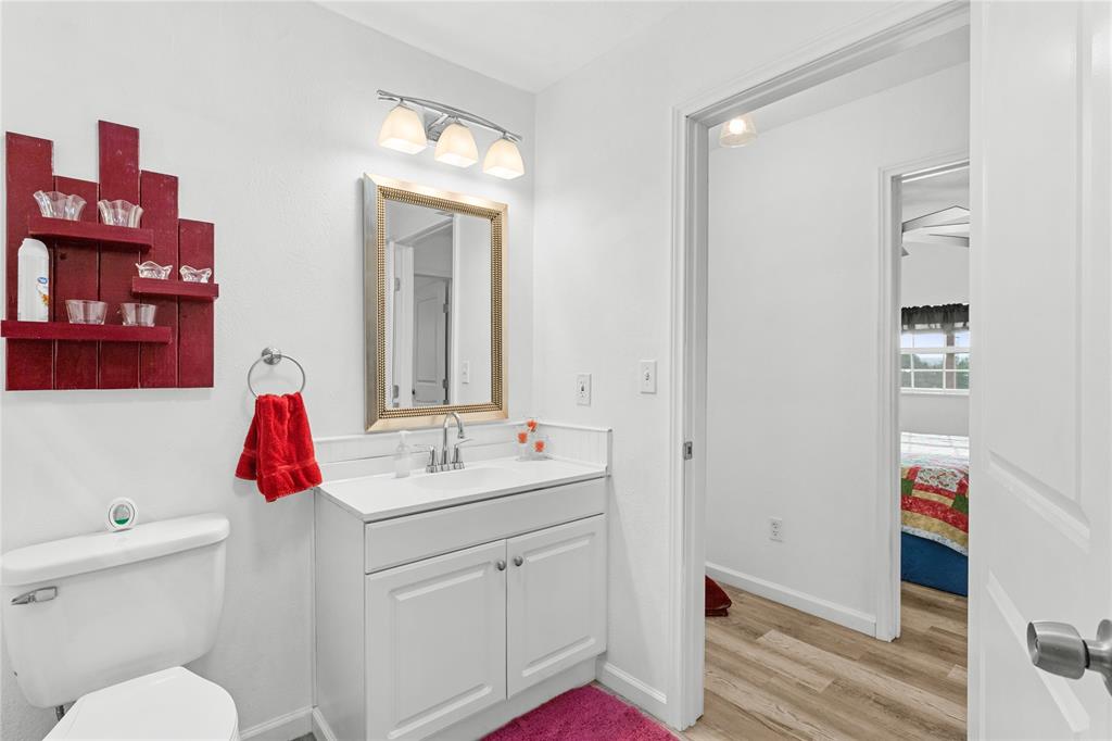351 County Road 2601 Meridian, TX 76665 - Photo 27 of 40 a bathroom with a sink vanity mirror and toilet