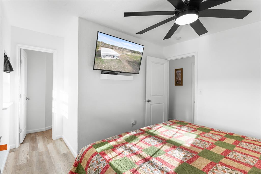 351 County Road 2601 Meridian, TX 76665 - Photo 33 of 40 a bedroom with a bed and a chandelier