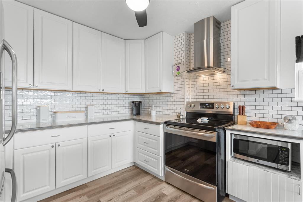 351 County Road 2601 Meridian, TX 76665 - Photo 35 of 40 a kitchen with white cabinets and appliances