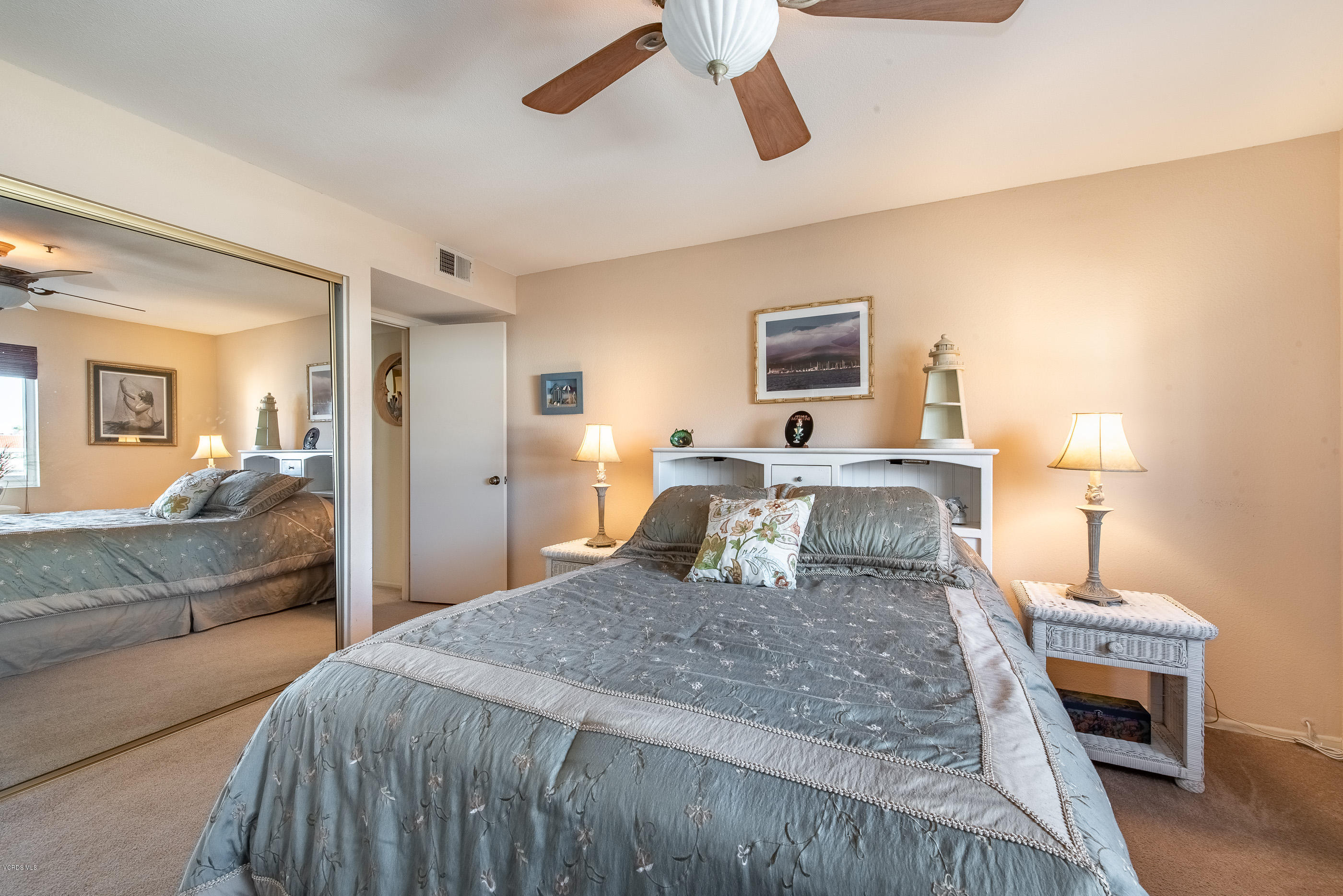 2872 Coast Circle, Unit 203 Huntington Beach, CA 92649 - Photo 29 of 42 a bedroom with a large bed and a chandelier