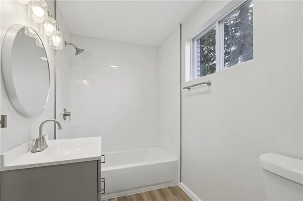 a view of an empty room with wooden floor and closet
