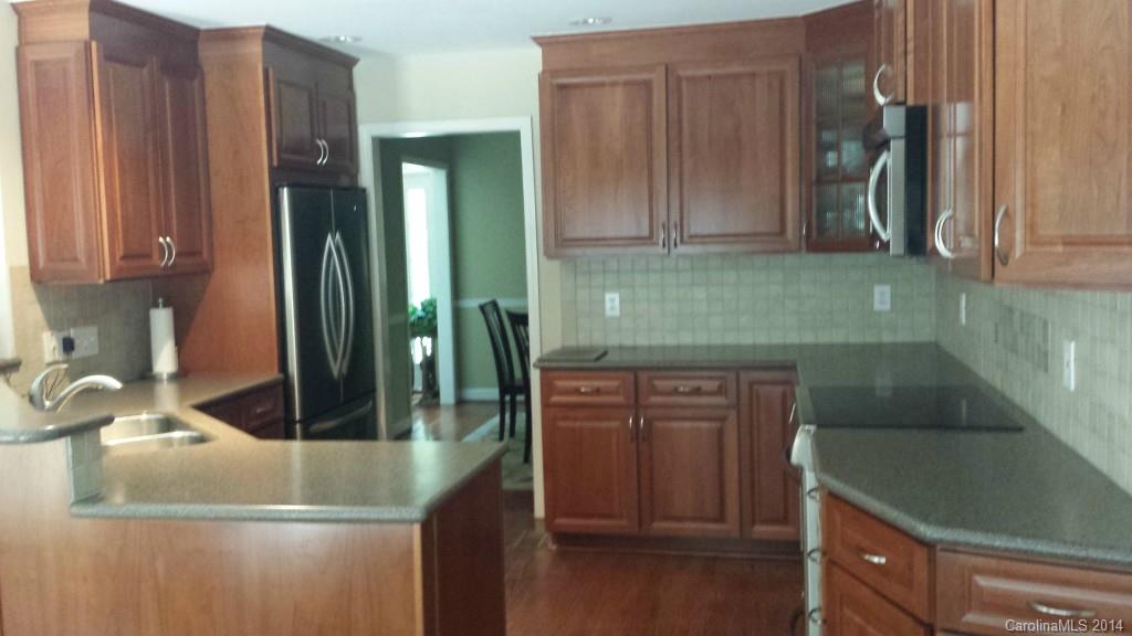 5465 Deer Run Court Davidson, NC 28036 - Photo 2 of 15 a kitchen with kitchen island granite countertop a sink a stove and cabinets