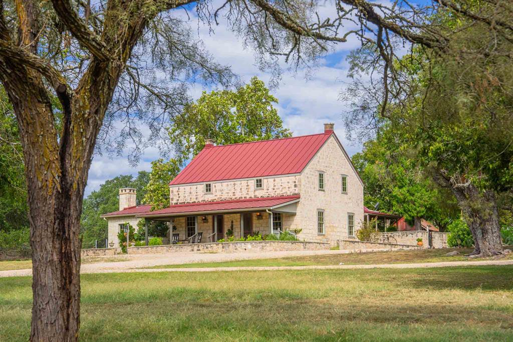 6754 North Grape Creek Road Fredericksburg, TX 78624 - Photo 1 of 47 a front view of a house with a yard table and chairs