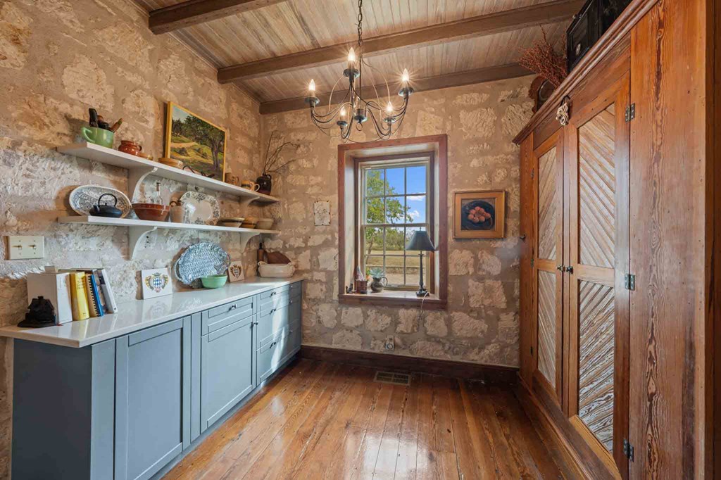 6754 North Grape Creek Road Fredericksburg, TX 78624 - Photo 16 of 47 a view of a hallway to dining room with wooden floor and windows
