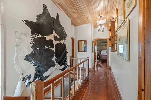 a spacious bedroom with a bed and a flat tv screen on wall