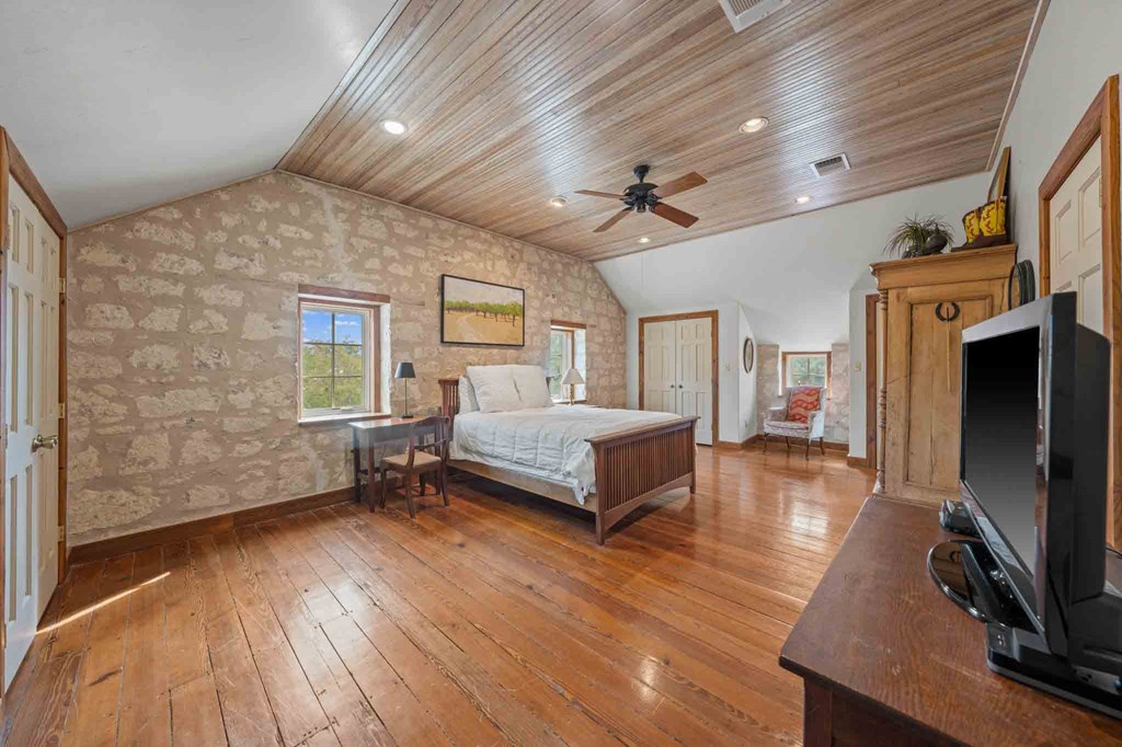 6754 North Grape Creek Road Fredericksburg, TX 78624 - Photo 24 of 47 a spacious bedroom with a bed and a flat tv screen on wall