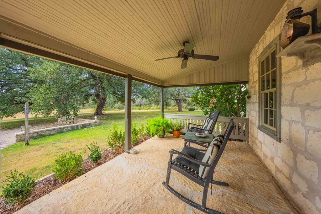 6754 North Grape Creek Road Fredericksburg, TX 78624 - Photo 9 of 47 a view of a patio with chairs and floor to ceiling window