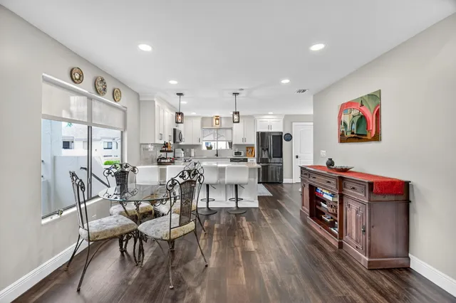 a view of a dining room with furniture a chandelier and wooden floor