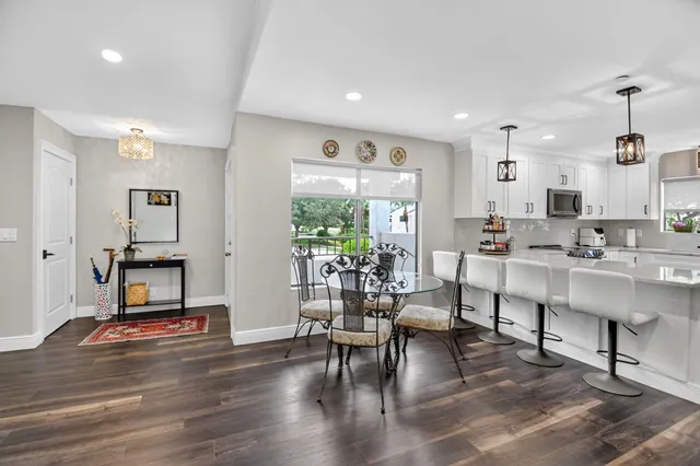 a living room with furniture kitchen view and a wooden floor