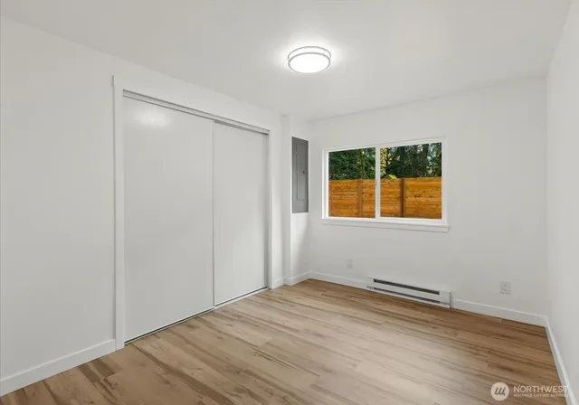 an empty room with wooden floor and windows