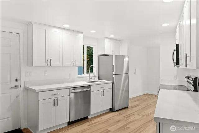 a kitchen with a sink appliances and cabinets