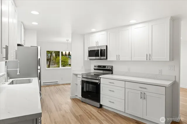 a kitchen with white cabinets and stainless steel appliances
