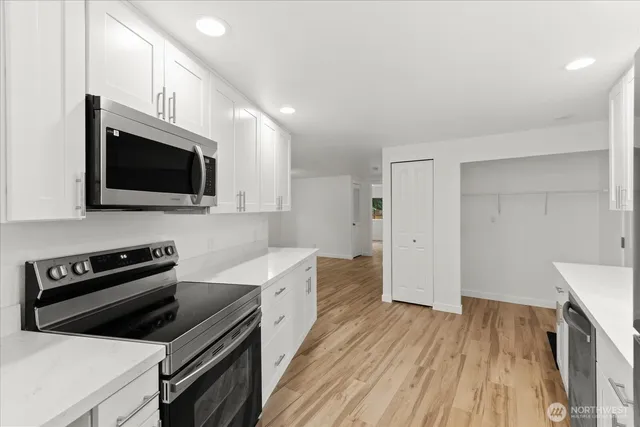a kitchen with a sink a microwave and cabinets