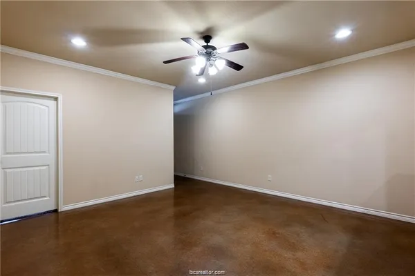 an empty room with a fan and a ceiling fan