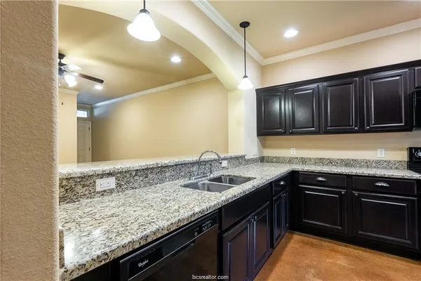 a kitchen with a sink and a stove top oven with wooden floor